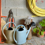 Roll up hoses and tidy up tools in garden shed.